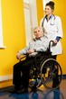 © Nejron Photo - Cheerful young nurse woman with senior man in wheelchair