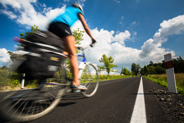 Female cyclist biking on a country road on a lovely sunny day