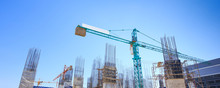 Building Crane And Construction Site Under   Blue Sky