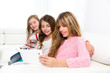© lunamarina - three kid sister friends girls playing together with tablet pc