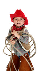 cute young cowboy playing with rope