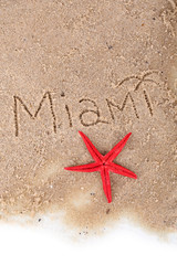 Inscription Miami in wet sand close-up background