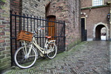 Fototapeta Na drzwi - White bicycle near the lattice in Binnenhof, Hague, Netherlands