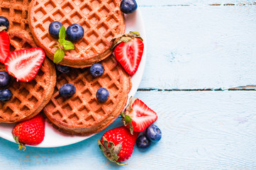 Sticker - Whole grain waffles with berries on blue wooden background