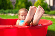 © travnikovstudio - Closeup of little kid's legs in small red pool