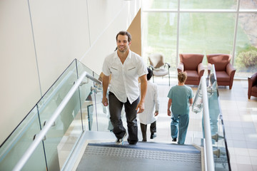 Wall Mural - Patient And Medical Team Walking On Stairs In Hospital