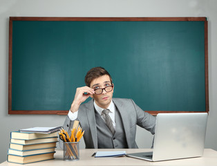 Canvas Print - Young teacher sitting in school classroom