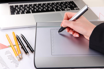 Canvas Print - Female hand using graphics tablet on table close up