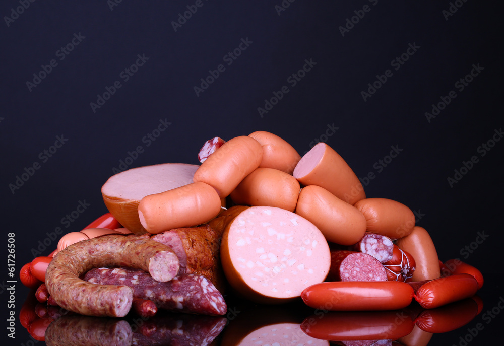Lot of different sausages on black background