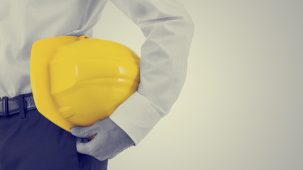 Businessman carrying a yellow hardhat