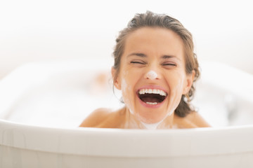 Wall Mural - Portrait of smiling young woman with foam on face 