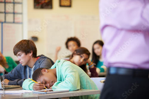 Fotografie, Obraz Bored High School Pupil Slumped On Desk In Classroom