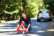 © lightpoet - Handsome young man with his car broken down by the roadside