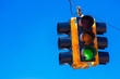 A green traffic light with a sky blue background