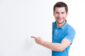 Wall Mural - Happy man points finger on a blank banner.