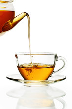 Tea Pouring Into Glass Cup Isolated In White