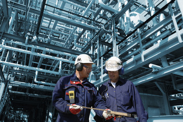 Wall Mural - oil workers inside large refinery industry