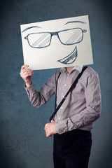 Wall Mural - Businessman holding a paper with smiley face in front of his hea