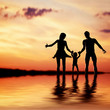 © Photocreo Bednarek - Happy family walking together hand in hand at sunset
