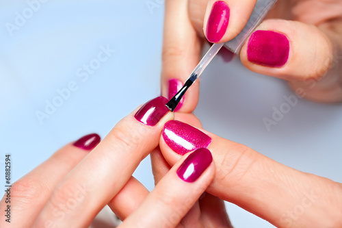 Dekoracja na wymiar  kobieta-nakladajaca-lakier-do-paznokci-na-paznokcie-u-rak