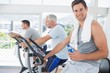© WavebreakMediaMicro - Man on exercise bike holding water bottle