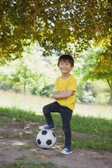 Wall Mural - Cute little boy with football at park