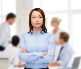 Canvas Print - smiling businesswoman with crossed arms at office