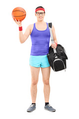 Canvas Print - Young male athlete with sports bag holding a basketball