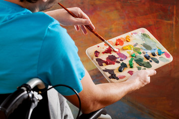 Man on wheelchair painting