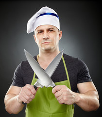 Man cook holding two big sharp knives