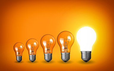 Wall Mural - Row of light bulbs.Idea concept on orange background.