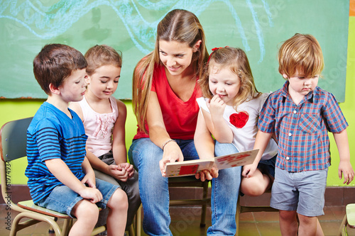 Fotografía Kinder mit Erzieher lesen Buch im Kindergarten