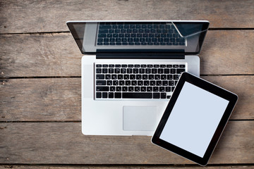 laptop and tablet on old wooden desk