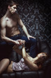 © Acronym - A young and sexy couple in erotic lingerie on a black sofa