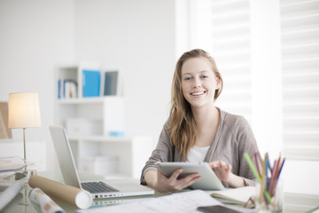 Wall Mural - beautiful young woman on the workplace using a digital tablet