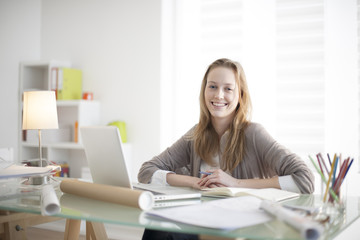 Wall Mural - beautiful young woman sitting at her desk in the workplace