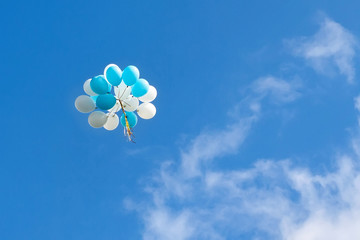a bunch of blue and white balloons in the sky
