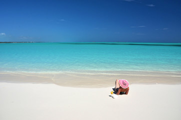 Wall Mural - Girl with a glass of orange on the beach of Exuma, Bahamas