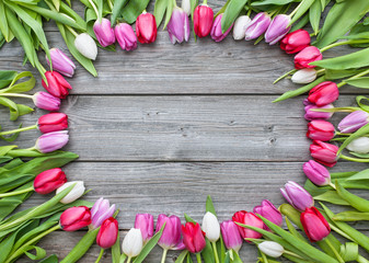 Wall Mural - Frame of fresh tulips arranged on old wooden background