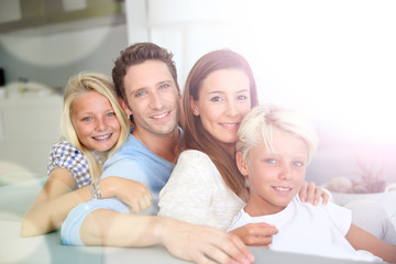 Wall Mural - Portrait of family relaxing in sofa