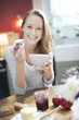 © jackfrog - cheerful young woman at breakfast in her kitchen