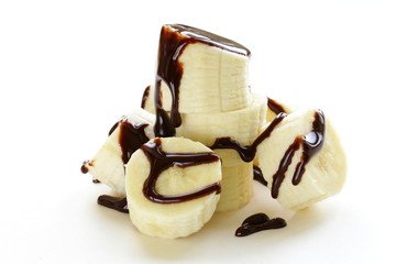 Wall Mural - fresh ripe banana with chocolate sauce on white background