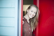© jackfrog - beautiful young woman opening a red door to welcome someone