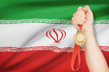 Medal in hand with flag on background - Islamic Republic of Iran