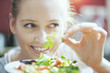 © jackfrog - Young woman in her kitchen holding an aromatic herb for her sala