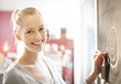 © jackfrog - beautiful young woman drawing a smiley face on a blackboard at h
