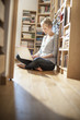 © jackfrog - young student sit on the floor working on her computer near fami