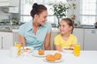 © lightwavemedia - Mother and daughter at breakfast table