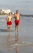 © travelview - father and son enjoy jogging along the beach