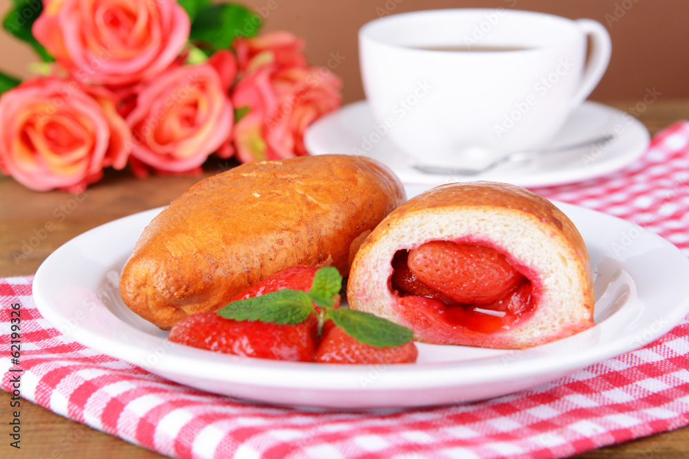 Fresh baked pasties with strawberries on plate on table